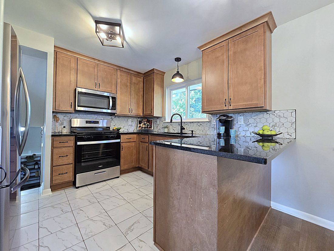 Second finished kitchen view with peninsula seating and updated lighting