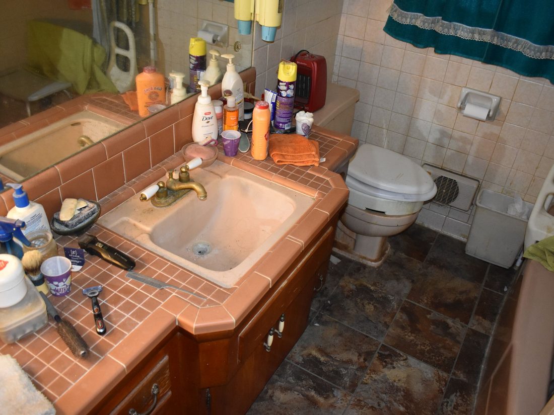1970s bathroom with tile counters and a pink sink before renovation