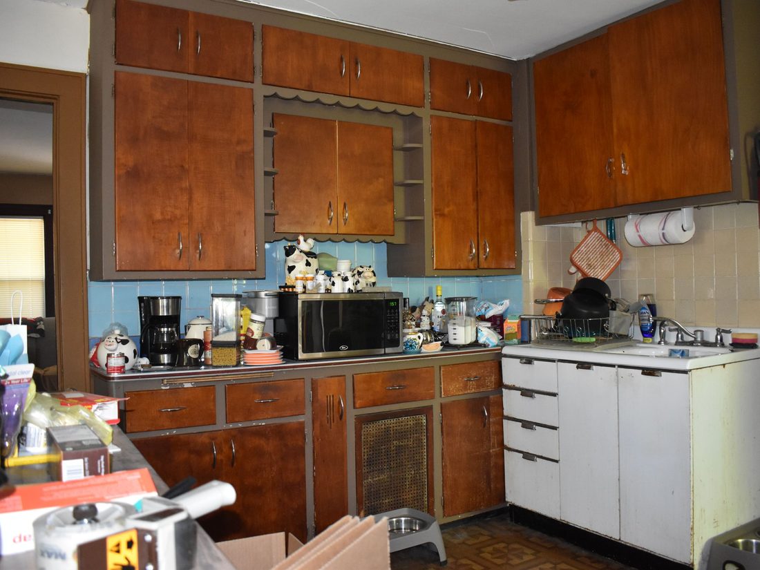 Two generations of cabinetry and a tiled backsplash in the original kitchen