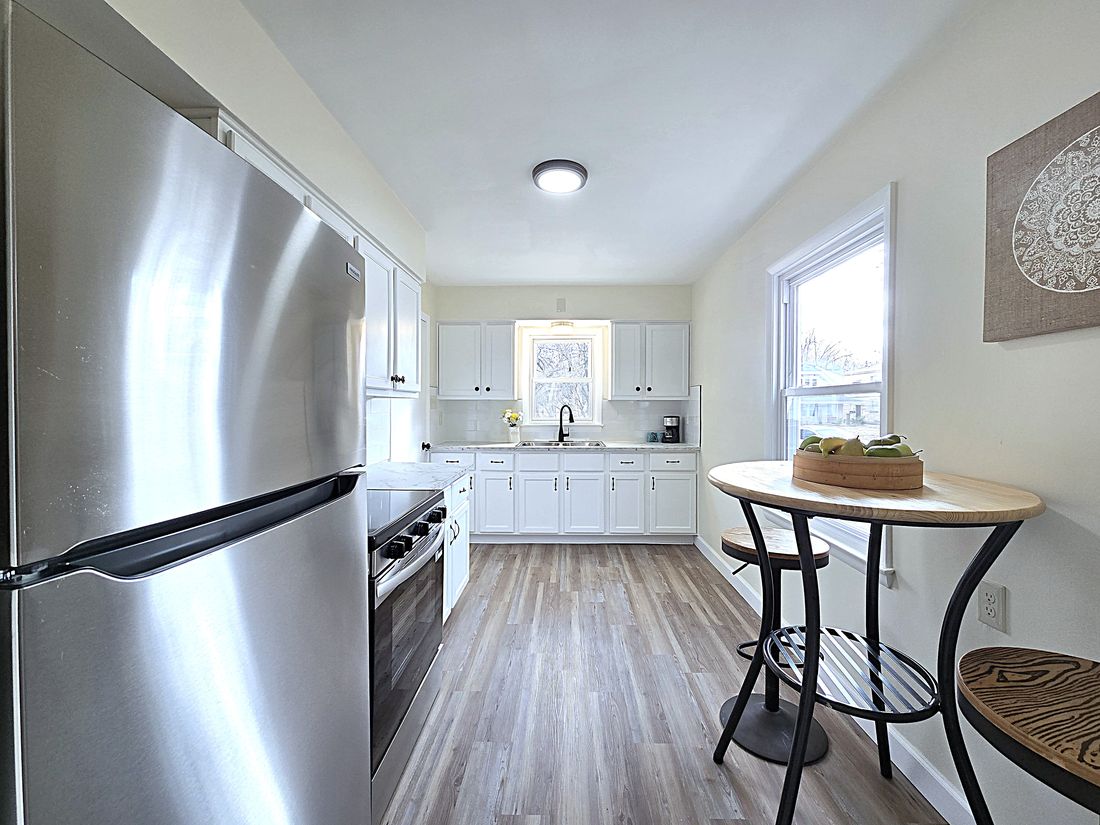 Updated kitchen with white cabinets, new counters, flooring and stainless appliances