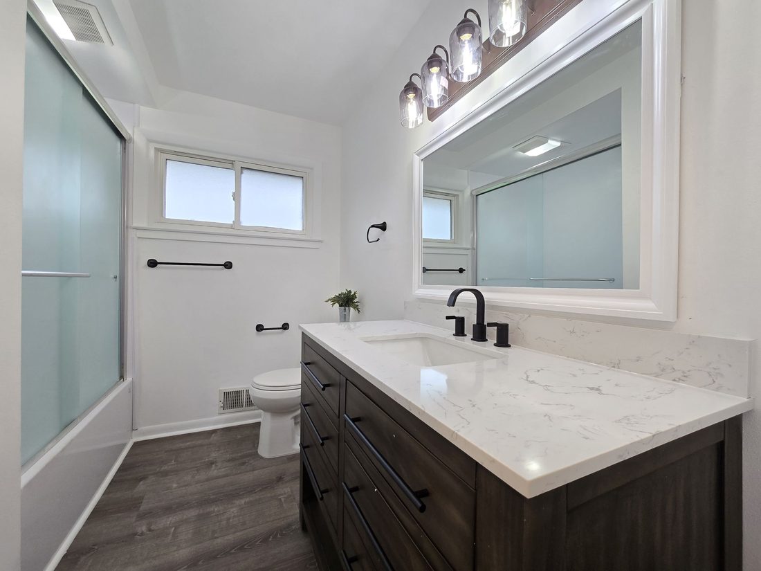 Remodeled bathroom with a new vanity, quartz top and tiled shower