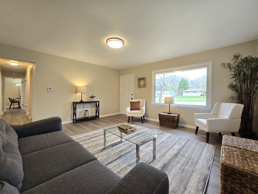 Renovated living room with new flooring and large windows in a Milwaukee home