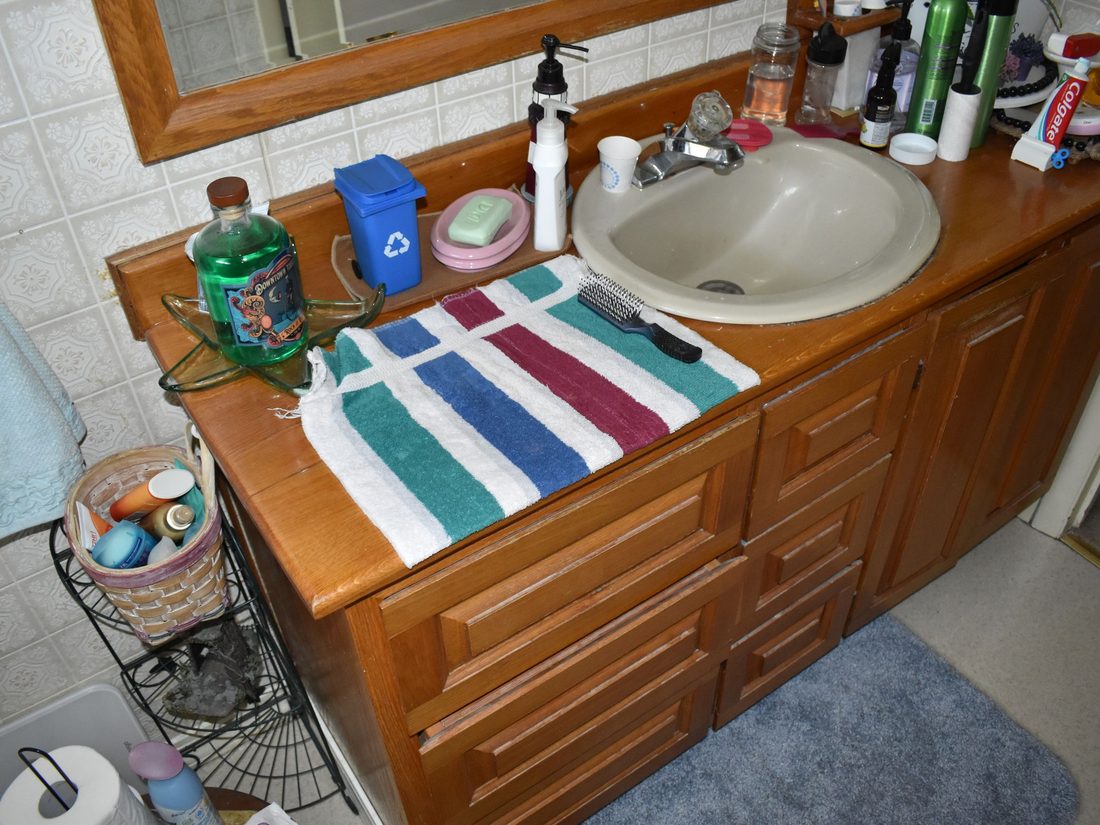Original bathroom with a dated wood vanity and tile counter