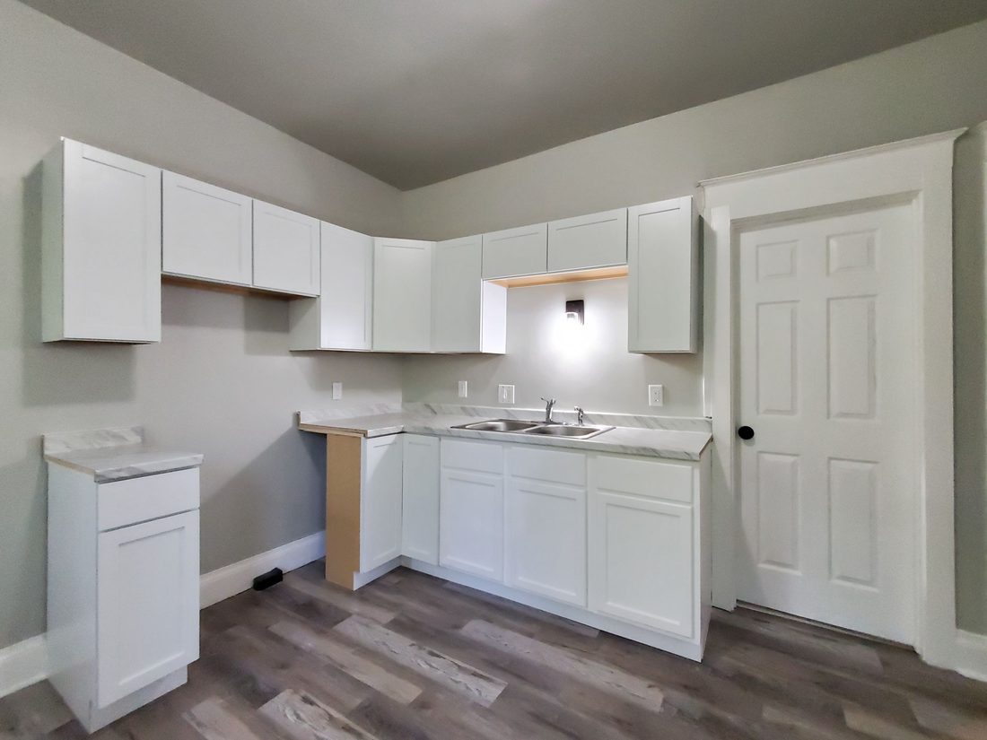 Rebuilt white kitchen with new counters and flooring in the Milwaukee rental