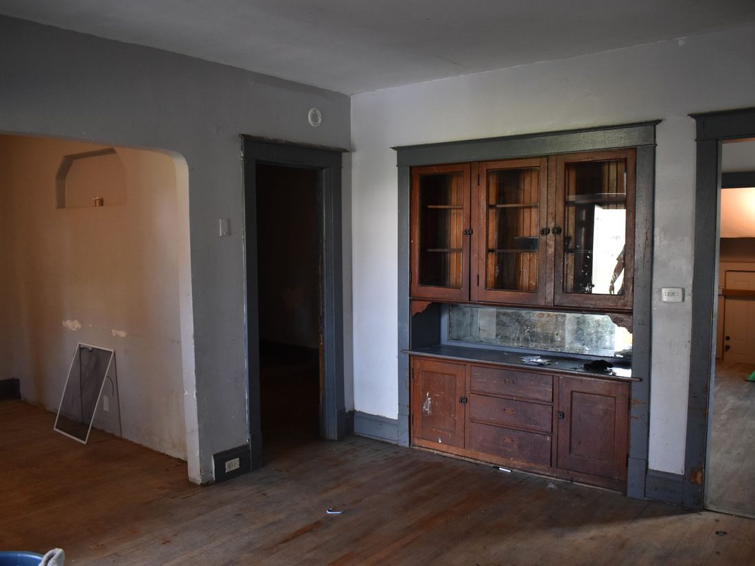 Original built-in buffet and worn walls in the vacant Milwaukee home