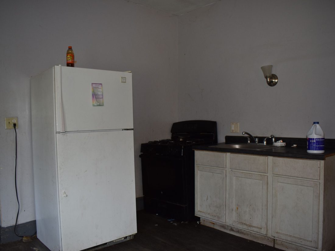Stripped kitchen with a single cabinet run before renovation