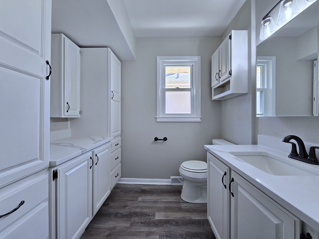 Remodeled main-floor bathroom with marble-look tile surround