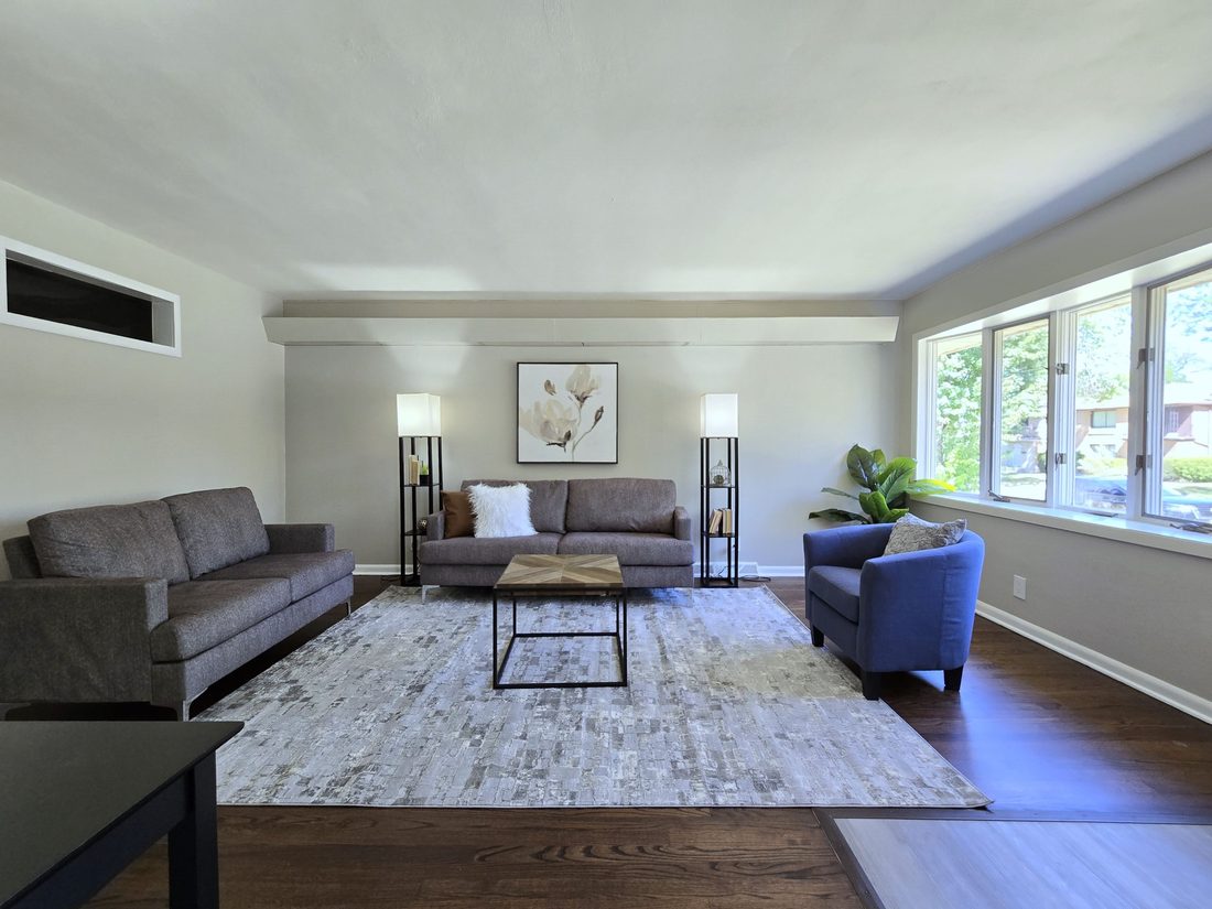 Renovated living room with new flooring, paint and lighting