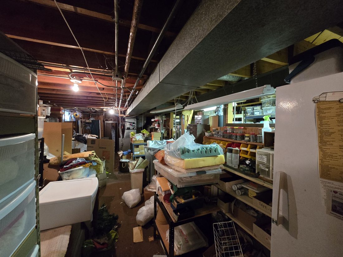 Basement packed with stored items and shelving before the cleanout