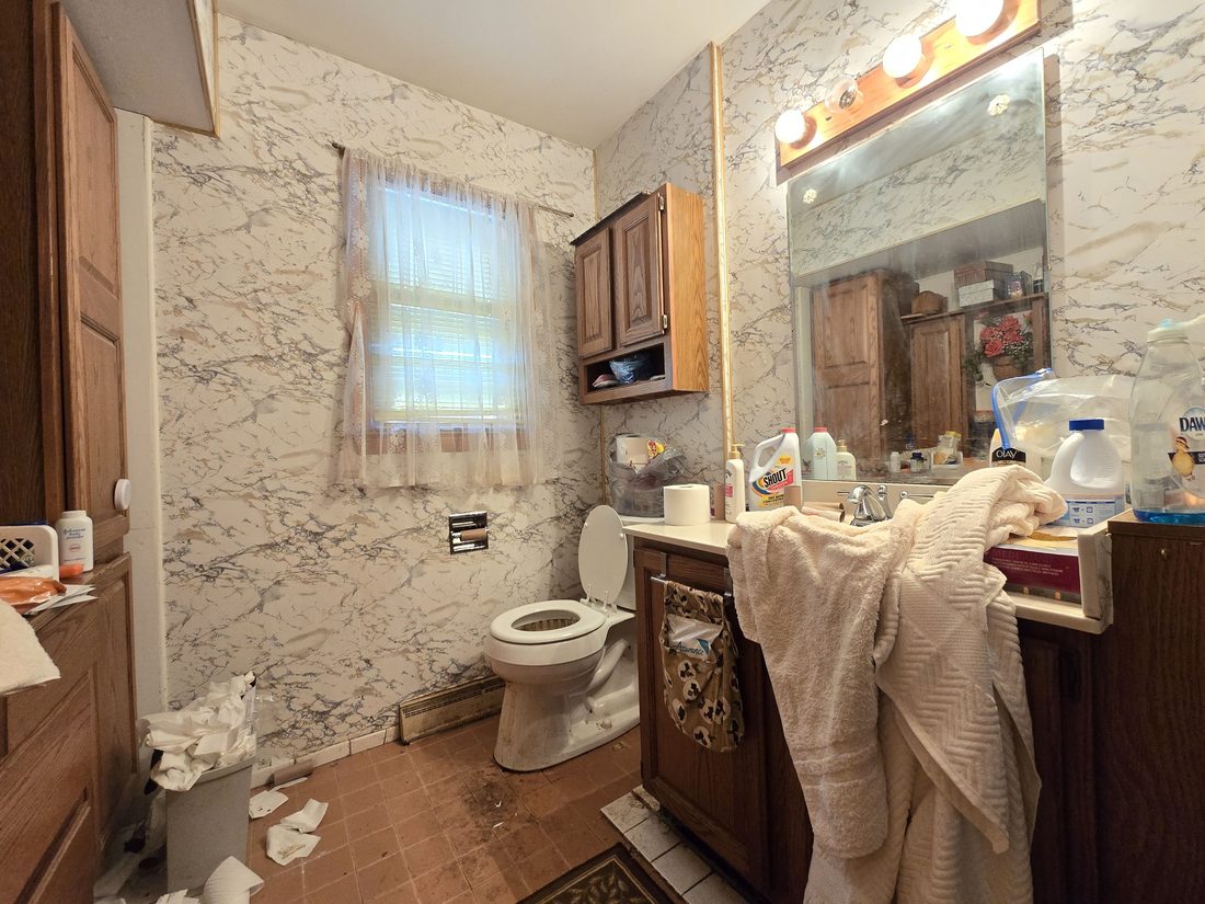 Original main-floor bathroom with dated vanity and fixtures