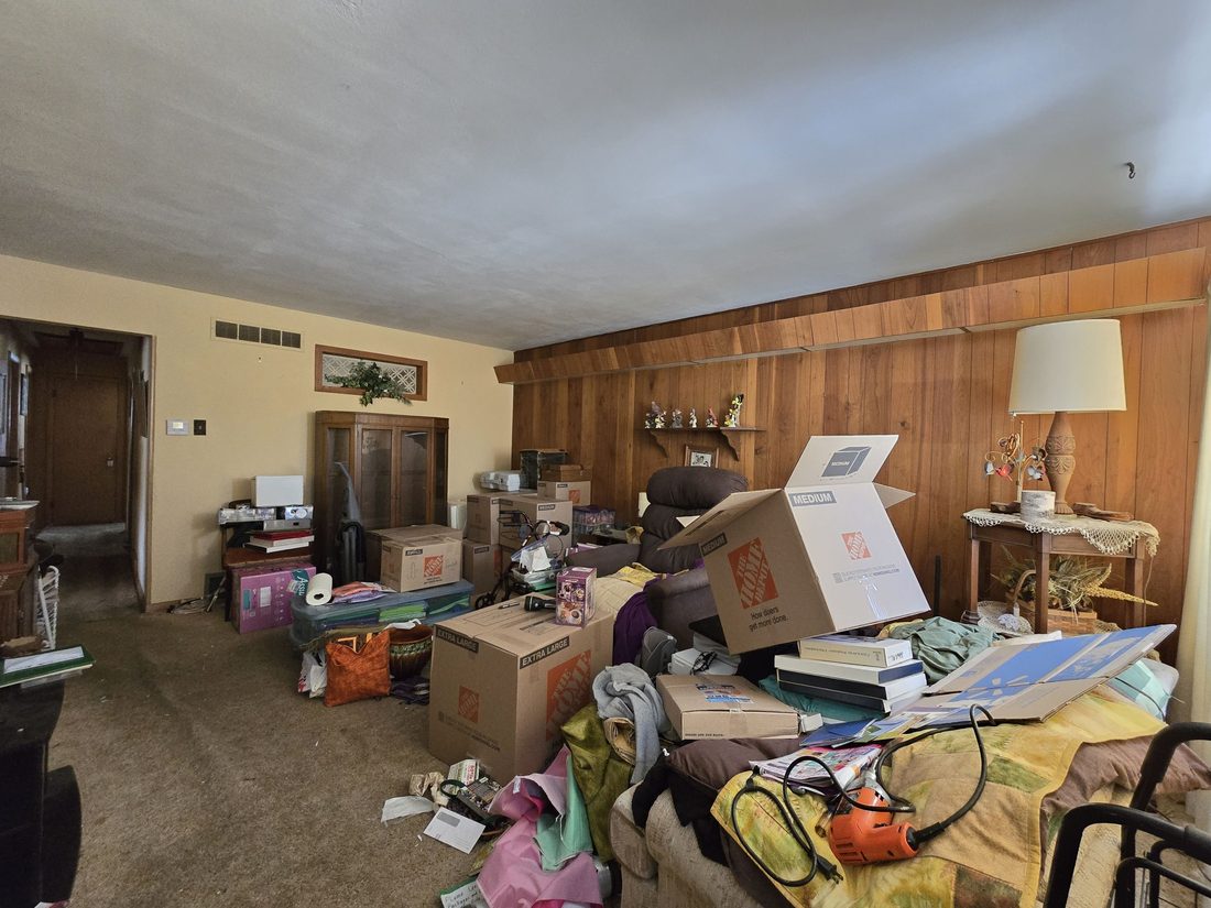 Second view of the cluttered living and dining area before renovation