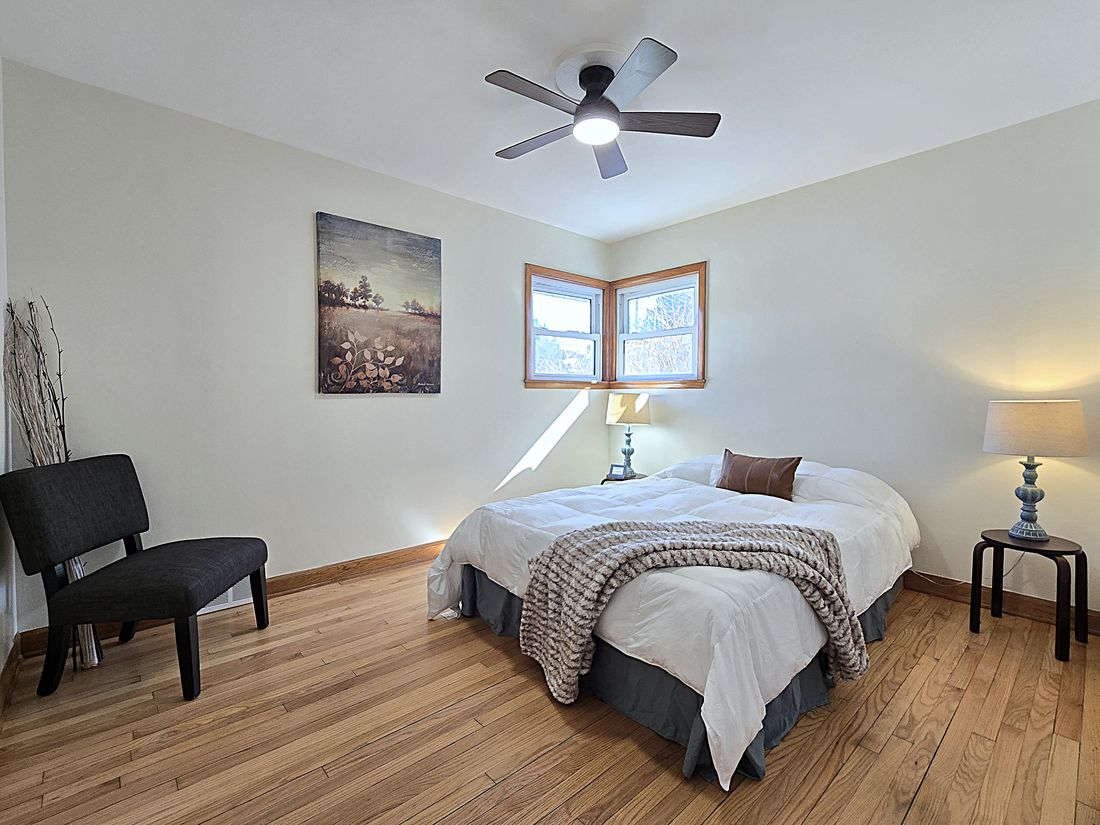 Renovated bedroom with refinished hardwoods and new ceiling fan