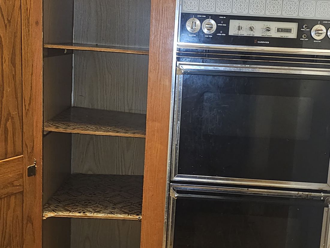 Original oak cabinetry and dated double wall oven