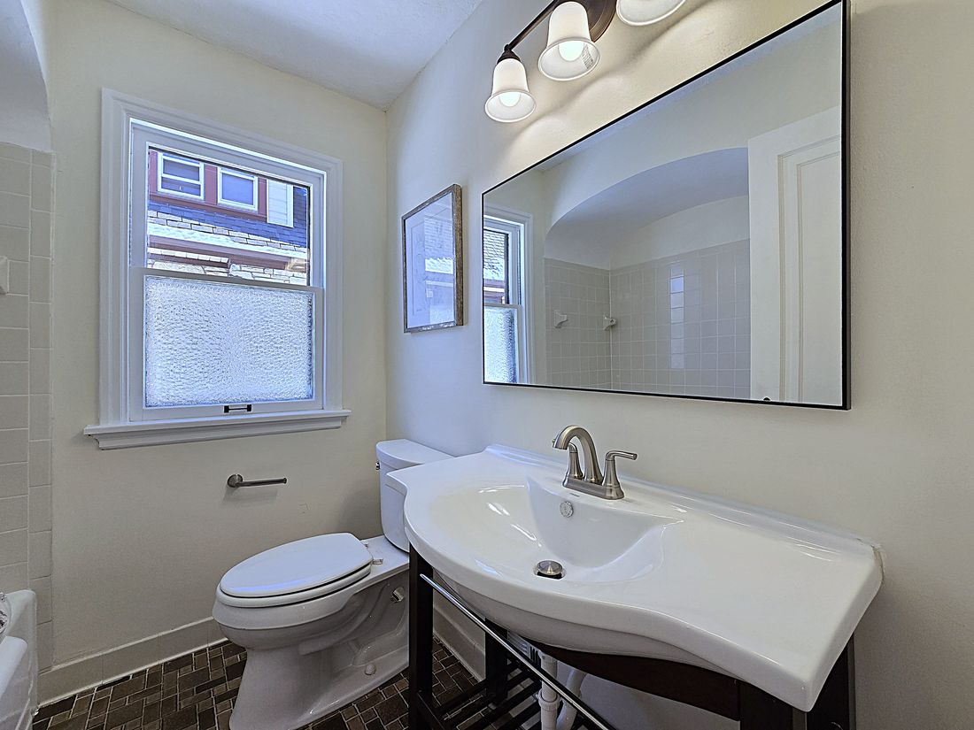 Refreshed bathroom keeping the original pedestal sink and tile