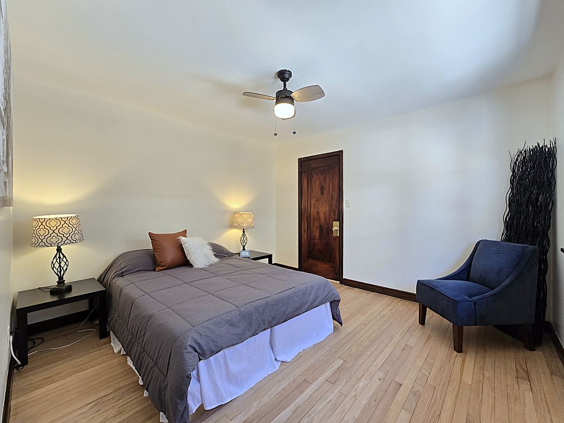 Renovated bedroom with refinished hardwoods and new ceiling fan