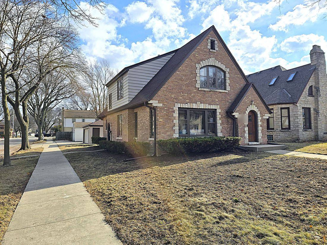 Brick Tudor in Waukesha after renovation, with the original stone-trimmed arched entry