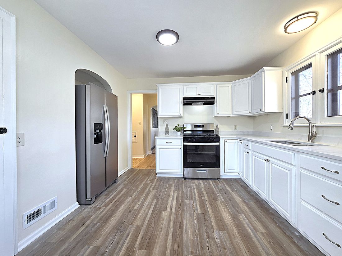 Updated white kitchen with new counters, flooring and stainless appliances